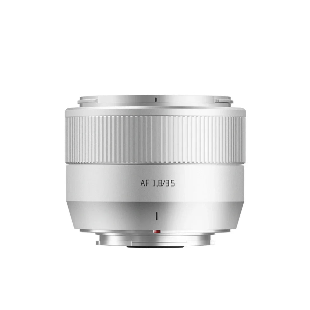 Silver camera lens with AF 1.8/35 marking and ribbed focus ring isolated on white