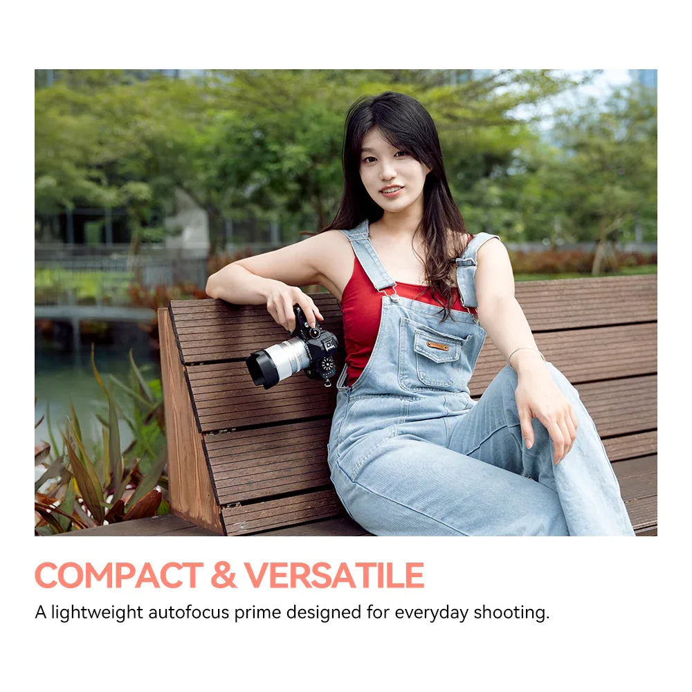 Silver camera lens mounted on black camera with white background, showcasing compact photography accessory