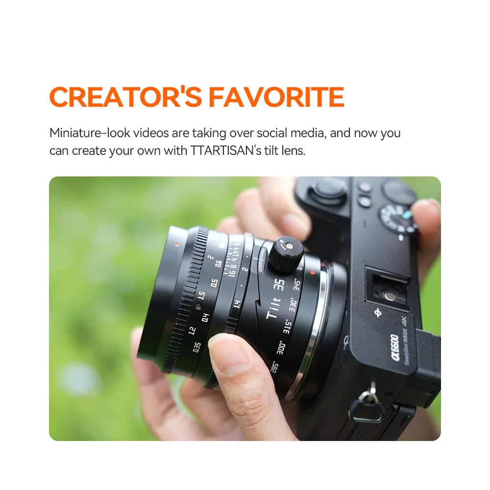 Hand adjusting TTARTISAN Tilt 35mm lens on Sony Alpha 6600 camera with blurred green background