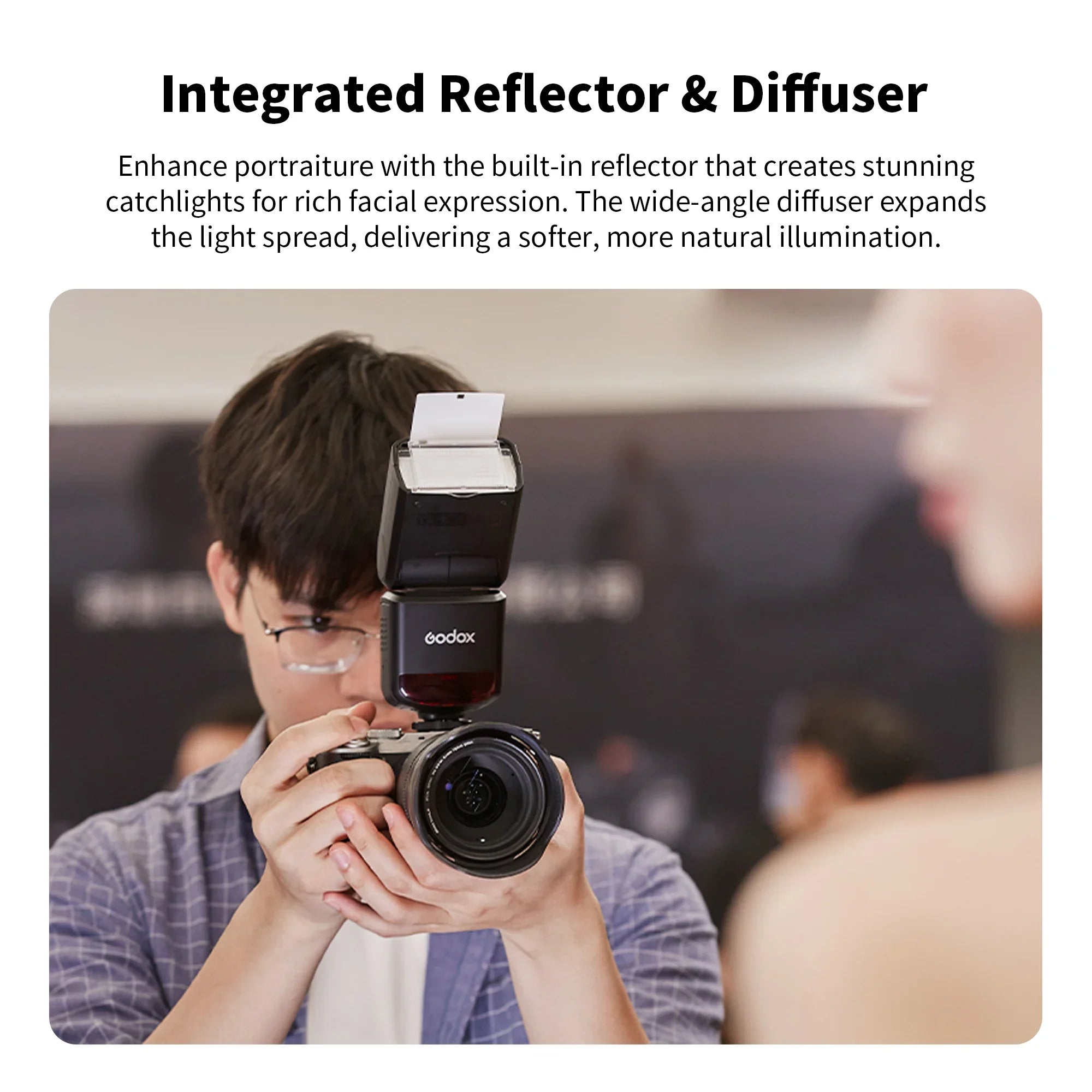 Photographer holding camera with Godox flash featuring integrated reflector and diffuser