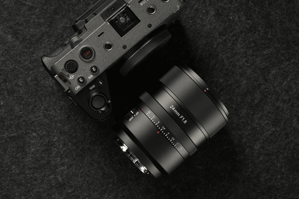 Top view of a black camera with 24mm F1.8 lens on dark textured surface