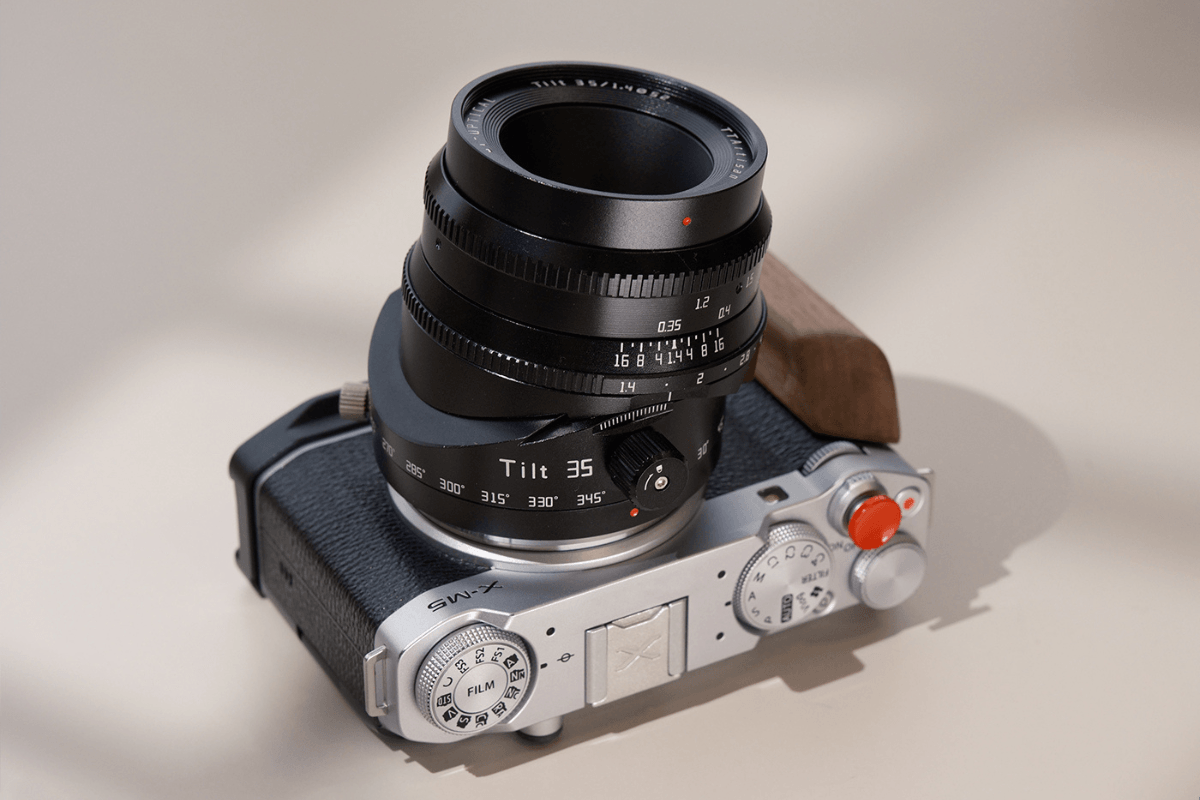 Fujifilm X-M5 mirrorless camera with a black tilt 35mm camera lens on a neutral background