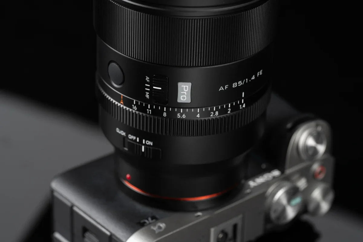 Close-up of a Pro AF 85mm f/1.4 FE camera lens mounted on a digital mirrorless camera